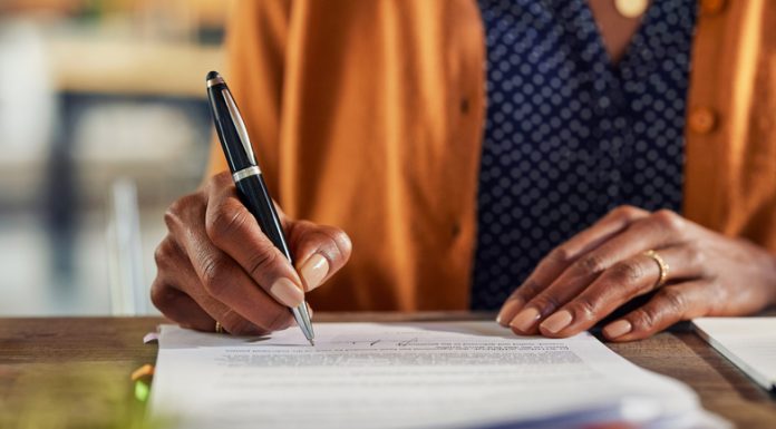Cheap and Cheerful or Built to Last? Choosing the Right Pen for the Job Close up of african american business woman hand writing on report while working in office. Successful black businesswoman signing documents at home using a pen.