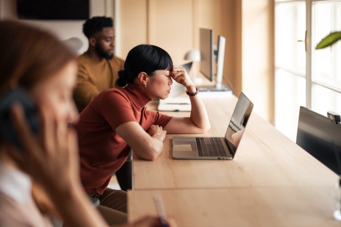 Woman Focused on Laptop in Modern Office Setting Europe’s Workplace Wellbeing