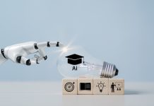 Employers Everywhere are Using AI – but Business Schools aren’t Preparing Students for the Shift A hand with a light bulb, artificial intelligence (AI) learning, educational tools, video-based instruction, digital courses, internet lessons, e-learning concepts.