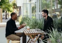 Help First, Sell Later: The Case for Giving Before You Pitch Two men talking over coffee at a small table outside a cafe. Value in business concept