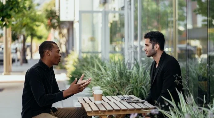 Help First, Sell Later: The Case for Giving Before You Pitch Two men talking over coffee at a small table outside a cafe. Value in business concept