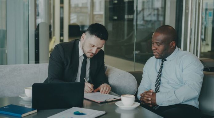 Data Rooms for European M&A: A Practical Guide for Dealmakers Two M&A advisers reviewing due diligence documents on a laptop, illustrating virtual data room preparation.