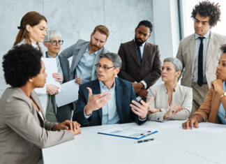 Young business people meeting office teamwork group success corporate senior mature colleague together. Leadership Behaviour concept