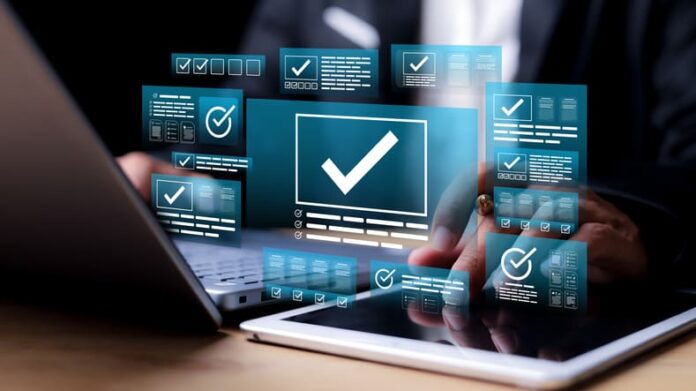 iStock-2219721263 (1) Businessman validating digital documents using futuristic interface with checkmark icons, quality assurance system, Website, compliance review, and document verification.