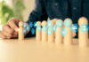 Before Delegating To AI, Business Owners Should Know They Own The Outcome Hand choose wooden doll stand group teamwork with business planning icon concept of relationship or HR human resources officer or business team and personnel management job performance.AI Delegation concept