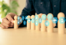 Before Delegating To AI, Business Owners Should Know They Own The Outcome Hand choose wooden doll stand group teamwork with business planning icon concept of relationship or HR human resources officer or business team and personnel management job performance.AI Delegation concept