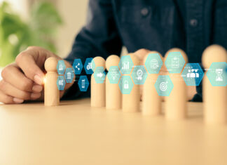 Before Delegating To AI, Business Owners Should Know They Own The Outcome Hand choose wooden doll stand group teamwork with business planning icon concept of relationship or HR human resources officer or business team and personnel management job performance.AI Delegation concept