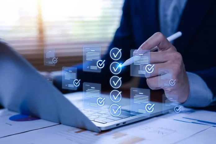Business professional verifying digital documents and checklist on tablet, representing document approval, compliance management, workflow automation, quality assurance, paperless office. UK company compliance checklist