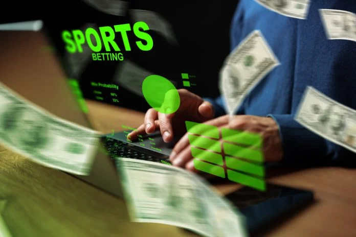 A person engages in sports betting online while handling cash in a dark setting Sports Betting with dollars